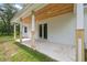 Covered patio with wood accents, leading to a bright white house with lush green surroundings at 2288 Rackley Rd, Brooksville, FL 34604