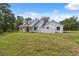 Bright white home featuring a covered patio, fenced yard, and lush green lawn at 2288 Rackley Rd, Brooksville, FL 34604