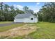Charming white home with a gray roof, surrounded by lush green grass and mature trees at 2288 Rackley Rd, Brooksville, FL 34604