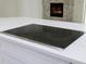 Close-up of the kitchen island's electric cooktop with white marble countertop and white cabinets at 2288 Rackley Rd, Brooksville, FL 34604