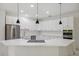 Bright, open kitchen with white cabinets, stainless steel appliances, and a large island with a cooktop at 2288 Rackley Rd, Brooksville, FL 34604
