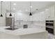 Bright, open kitchen with white cabinets, stainless steel appliances, and a large island with a cooktop at 2288 Rackley Rd, Brooksville, FL 34604