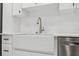Close-up of white farmhouse sink, stainless steel faucet, and stainless steel dishwasher at 2288 Rackley Rd, Brooksville, FL 34604