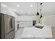 Bright, open kitchen with white cabinets, stainless steel appliances, and a large island with a cooktop at 2288 Rackley Rd, Brooksville, FL 34604