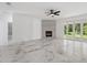 Spacious living room featuring marble flooring, a stone fireplace, and large glass doors at 2288 Rackley Rd, Brooksville, FL 34604
