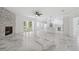 Modern living room with marble floors, a stone fireplace, and an adjacent kitchen at 2288 Rackley Rd, Brooksville, FL 34604
