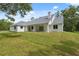 Rear of the house featuring a covered patio, bright white exterior, and lush green lawn at 2288 Rackley Rd, Brooksville, FL 34604