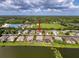 Aerial shot of a lakeside property featuring a sparkling screened in pool and a well-manicured lawn and landscaping at 2326 Mountain Ash Way, New Port Richey, FL 34655