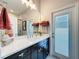 Bright bathroom features a double vanity with sleek fixtures, stylish decor, and a door to the lanai at 2326 Mountain Ash Way, New Port Richey, FL 34655