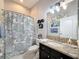 Bathroom with a granite countertop, vanity, and patterned shower curtain at 2326 Mountain Ash Way, New Port Richey, FL 34655