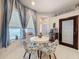 Bright breakfast nook with large windows and a round table with stylish floral-patterned chairs at 2326 Mountain Ash Way, New Port Richey, FL 34655