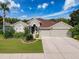 Charming single-Gathering home with a well-manicured front lawn and a three-car garage at 2326 Mountain Ash Way, New Port Richey, FL 34655