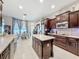 Spacious kitchen featuring dark wood cabinets, stainless steel appliances, and a center island with marble countertop at 2326 Mountain Ash Way, New Port Richey, FL 34655
