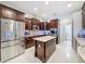 Spacious kitchen with stainless steel appliances, dark wood cabinets, and a central island at 2326 Mountain Ash Way, New Port Richey, FL 34655