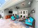 Charming lanai with a ceiling fan, comfortable seating, a TV, and a tranquil view of the sparkling pool area at 2326 Mountain Ash Way, New Port Richey, FL 34655