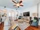 Open-concept living room with hardwood floors, ceiling fan, and cozy furniture arrangement at 2326 Mountain Ash Way, New Port Richey, FL 34655