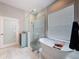 Luxurious bathroom with a freestanding tub, glass shower, and marble accents at 2326 Mountain Ash Way, New Port Richey, FL 34655