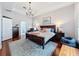 Elegant main bedroom with hardwood floors, a chandelier, and a view into the en-suite bathroom at 2326 Mountain Ash Way, New Port Richey, FL 34655
