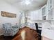 Well-lit home office with custom cabinetry, hardwood floors, and a comfortable seating area at 2326 Mountain Ash Way, New Port Richey, FL 34655