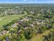 Aerial view of homes surrounded by lush greenery and a golf course with a tranquil lake at 2342 Countryside Dr, Spring Hill, FL 34606