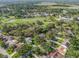 Scenic aerial view of a residential area featuring a golf course, lake, and tree-lined streets at 2342 Countryside Dr, Spring Hill, FL 34606