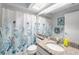 Well-lit bathroom featuring granite countertops, a vanity, toilet and a shower with blue curtain at 2342 Countryside Dr, Spring Hill, FL 34606