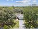 Overhead view of a charming home with a long driveway surrounded by mature trees and lush greenery at 2404 Knoll Dr, Spring Hill, FL 34608