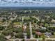 Charming aerial shot of a residential area featuring lush greenery, single-Gathering homes, and clear blue skies at 2404 Knoll Dr, Spring Hill, FL 34608