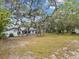 Expansive backyard featuring mature trees, a screened-in pool, and ample green space at 2404 Knoll Dr, Spring Hill, FL 34608