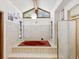 Bright bathroom with a red jacuzzi tub, tiled walls, and a large window providing natural light at 2404 Knoll Dr, Spring Hill, FL 34608