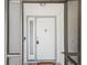Close up of a white front door framed by glass panels and the security of a screen door at 2404 Knoll Dr, Spring Hill, FL 34608