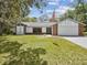 Charming single-story home with brick and white siding, an attached garage and a well-manicured front lawn at 2404 Knoll Dr, Spring Hill, FL 34608