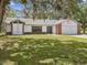 Well-maintained one-story home with attached garage, brick detail, and a welcoming front lawn at 2404 Knoll Dr, Spring Hill, FL 34608