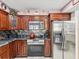 Kitchen with stainless steel appliances, dark wood cabinets, and dark granite countertops at 2404 Knoll Dr, Spring Hill, FL 34608