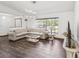 Inviting living room boasts a cozy atmosphere with laminate floors, large windows, and a stylish sectional sofa at 2404 Knoll Dr, Spring Hill, FL 34608