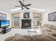 Open living room with tile flooring, fireplace, and comfortable seating under a vaulted ceiling with a skylight at 2404 Knoll Dr, Spring Hill, FL 34608