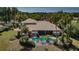 Aerial view of a home's backyard oasis with pool, patio, palm trees, and meticulously landscaped grounds at 2987 Wentworth Way, Tarpon Springs, FL 34688
