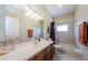 Bathroom with a large mirror, vanity, modern lighting, and a shower-tub combo, providing a functional space at 2987 Wentworth Way, Tarpon Springs, FL 34688