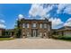 Elegant brick building with white trim, arched windows, manicured landscaping, and a paved driveway at 2987 Wentworth Way, Tarpon Springs, FL 34688