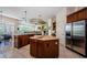 Bright kitchen featuring wood cabinets, kitchen island, and stainless steel refrigerator at 2987 Wentworth Way, Tarpon Springs, FL 34688