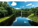 Picturesque pond with a fountain surrounded by lush greenery and mature trees, creating a tranquil atmosphere at 2987 Wentworth Way, Tarpon Springs, FL 34688