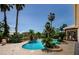 Resort-style pool featuring lush tropical landscaping, a waterfall feature, and surrounding brick pavers at 2987 Wentworth Way, Tarpon Springs, FL 34688