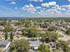 Expansive aerial view of a residential neighborhood with tree-lined streets, and a waterfront view in the distance at 3118 Lloyd Dr, Holiday, FL 34691