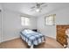The cozy bedroom features neutral carpet, a ceiling fan, and a wooden dresser at 3118 Lloyd Dr, Holiday, FL 34691