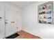 View of the front door and a built in shelving unit with decorative items on display in the entryway at 3118 Lloyd Dr, Holiday, FL 34691