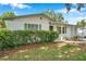 Home features a meticulously maintained lawn with an attached carport and shuttered windows at 3118 Lloyd Dr, Holiday, FL 34691