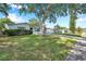 Residential street featuring manicured lawns, mature trees and sidewalks at 3118 Lloyd Dr, Holiday, FL 34691