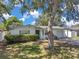 Charming single-story home with a lush green lawn, mature landscaping, and a classic white exterior at 3118 Lloyd Dr, Holiday, FL 34691