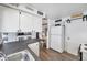 Bright kitchen with white cabinets, breakfast table, and a refrigerator with an adjacent sliding barn door at 3118 Lloyd Dr, Holiday, FL 34691