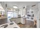 This open concept kitchen has white cabinets, countertops, and a breakfast bar with stools at 3118 Lloyd Dr, Holiday, FL 34691